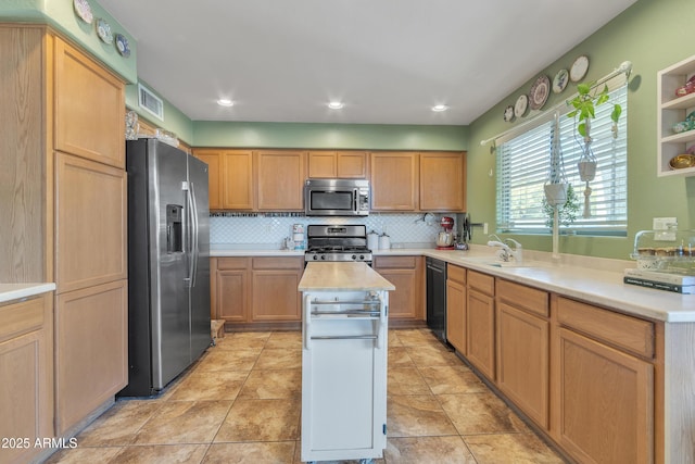 kitchen featuring visible vents, appliances with stainless steel finishes, a sink, light countertops, and backsplash