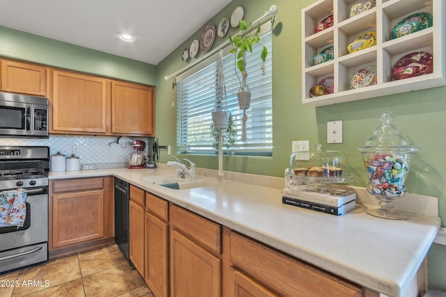 kitchen featuring open shelves, light countertops, decorative backsplash, appliances with stainless steel finishes, and a sink