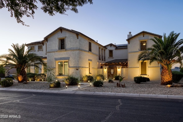 view of front of property featuring a chimney and stucco siding