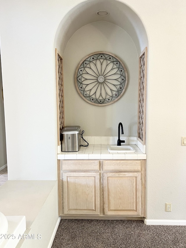 bar with carpet flooring, baseboards, and a sink