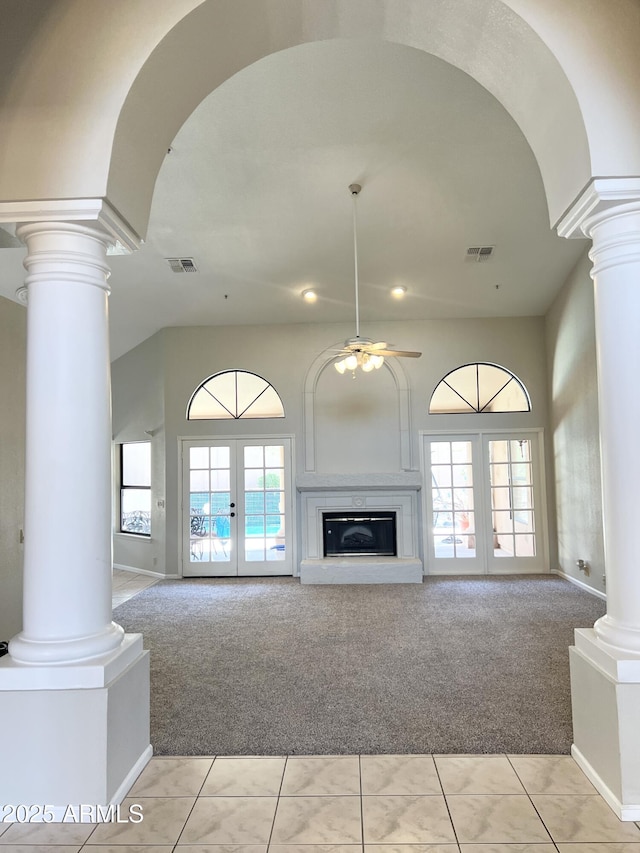 unfurnished living room featuring french doors, light colored carpet, visible vents, and ornate columns