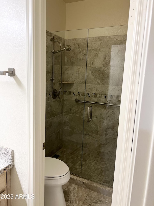 bathroom with vanity, toilet, and a shower stall