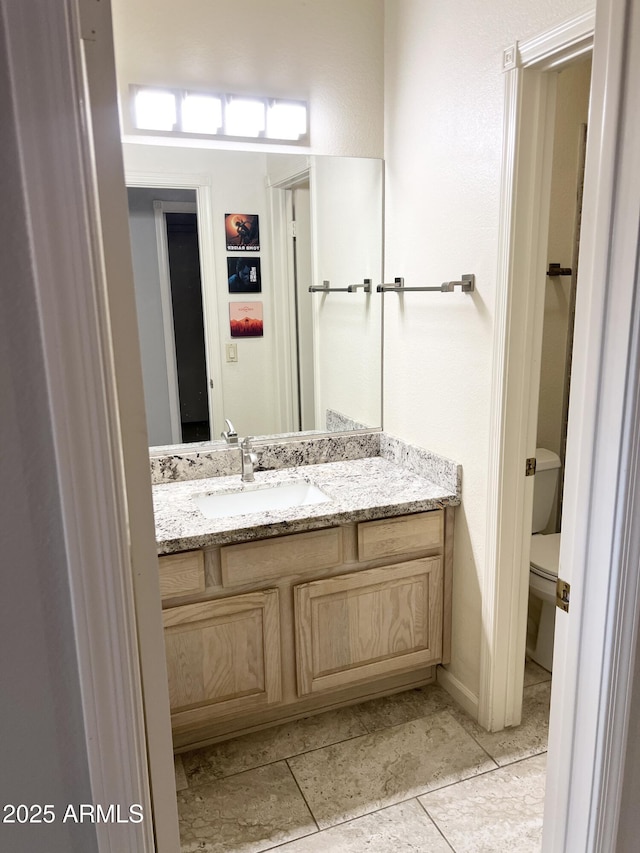 bathroom with toilet, vanity, and tile patterned flooring