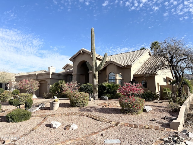 mediterranean / spanish house with stucco siding and a tiled roof