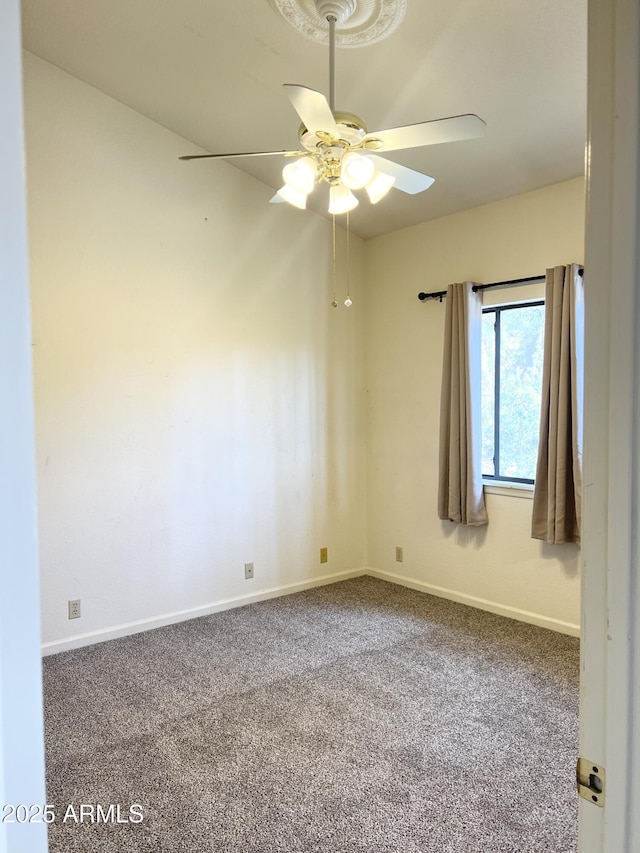 empty room featuring baseboards, carpet floors, and ceiling fan