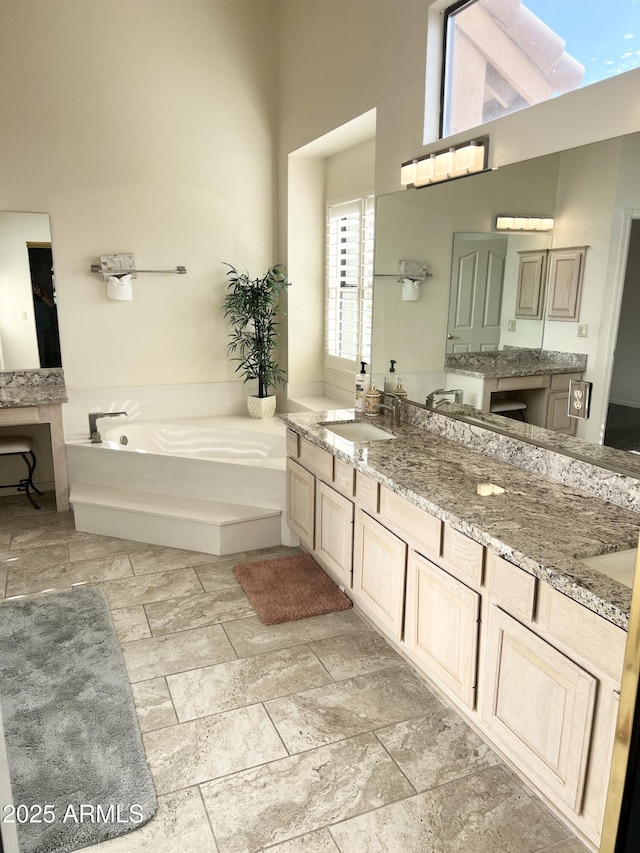 full bathroom with vanity and a bath