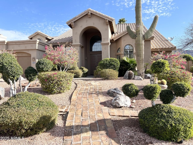 mediterranean / spanish home featuring stucco siding and an attached garage