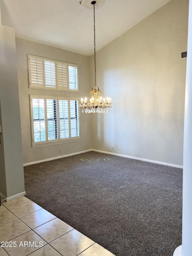 unfurnished dining area with high vaulted ceiling, carpet floors, an inviting chandelier, tile patterned flooring, and baseboards