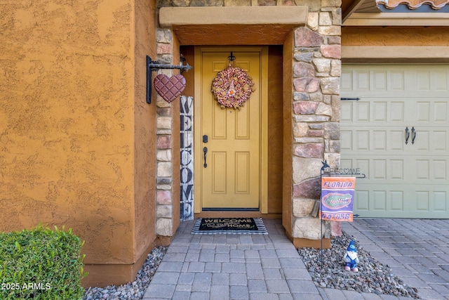 entrance to property with a garage and stone siding