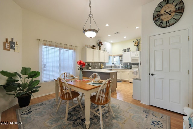 dining space with light wood finished floors, a wealth of natural light, and recessed lighting