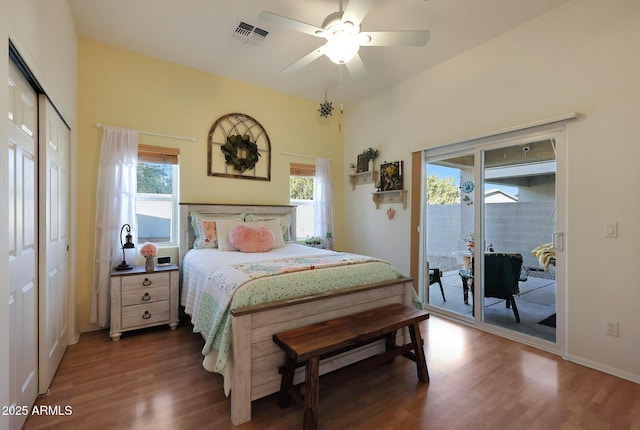 bedroom with access to exterior, a ceiling fan, visible vents, and wood finished floors