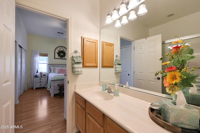 bathroom with visible vents, wood finished floors, ensuite bathroom, vanity, and a chandelier