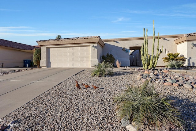 ranch-style house featuring driveway, an attached garage, and stucco siding