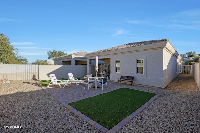 back of house with a patio area, a fenced backyard, and stucco siding