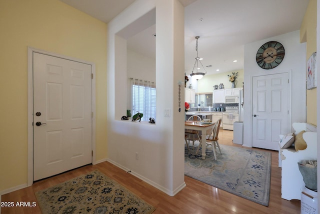 foyer featuring recessed lighting, light wood-style flooring, and baseboards