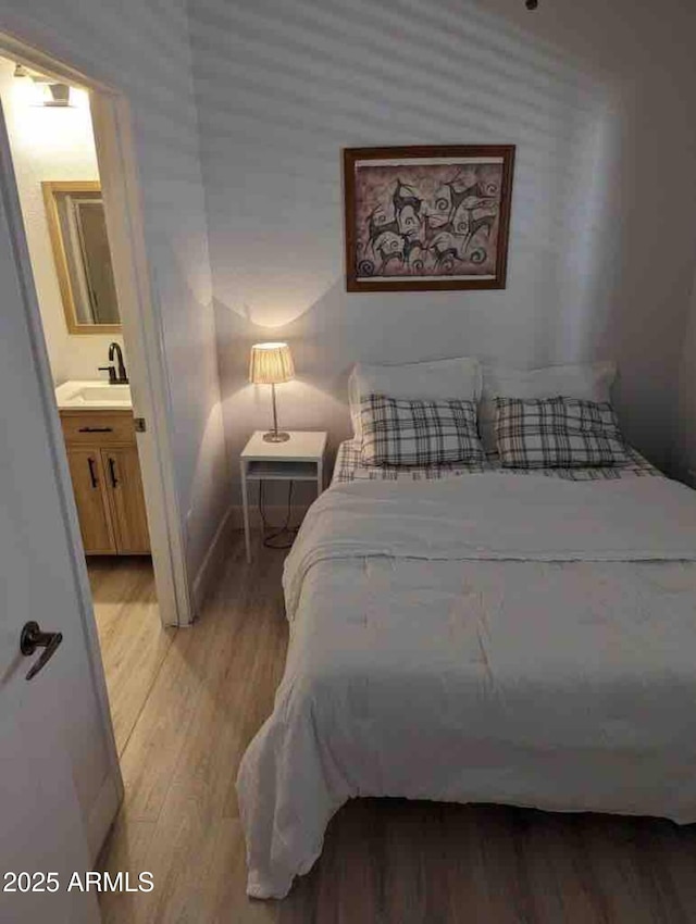 920 E Devonshire Ave Unit 2031, Phoenix, AZ 85014 - bedroom featuring light wood-style flooring, connected bathroom, and wallpapered walls