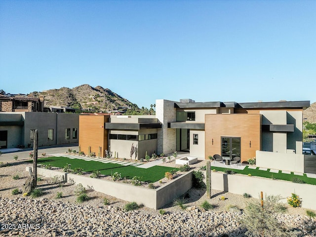 back of house with a mountain view and stucco siding