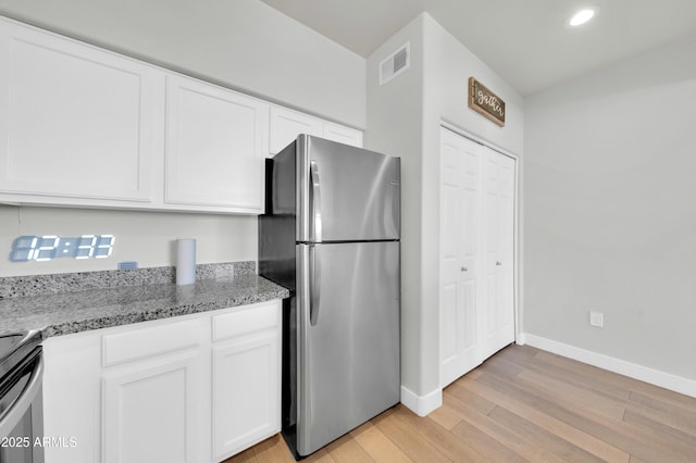 20100 N 78th Pl Unit 3103, Scottsdale, AZ 85255 - kitchen featuring freestanding refrigerator, light wood-type flooring, baseboards, white cabinetry, and light stone counters