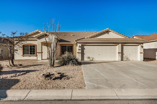 view of front of property with a garage, driveway, a tiled roof, and stucco siding