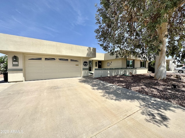 9318 W Briarwood Cir, Sun City, AZ 85351 - pueblo-style home with concrete driveway, stucco siding, and an attached garage