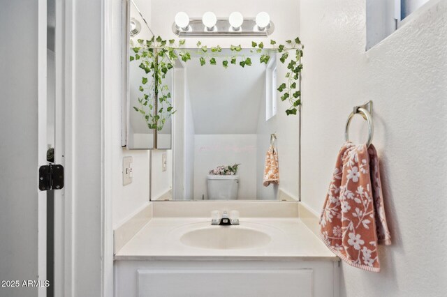 half bath featuring vanity and toilet