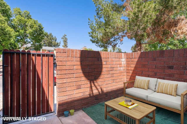 view of patio / terrace with outdoor lounge area, fence, and a gate