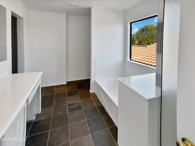 bathroom with a tub to relax in and vanity