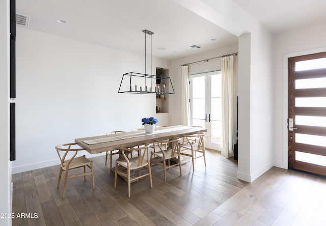 dining room featuring wood finished floors, baseboards, and recessed lighting