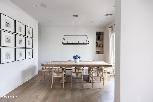 dining space featuring light wood-style floors, a chandelier, recessed lighting, and baseboards
