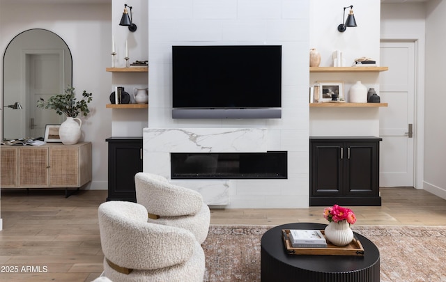 living room with a premium fireplace, wood finished floors, and baseboards