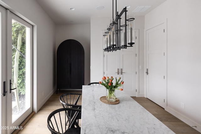 dining space with light wood-type flooring and baseboards