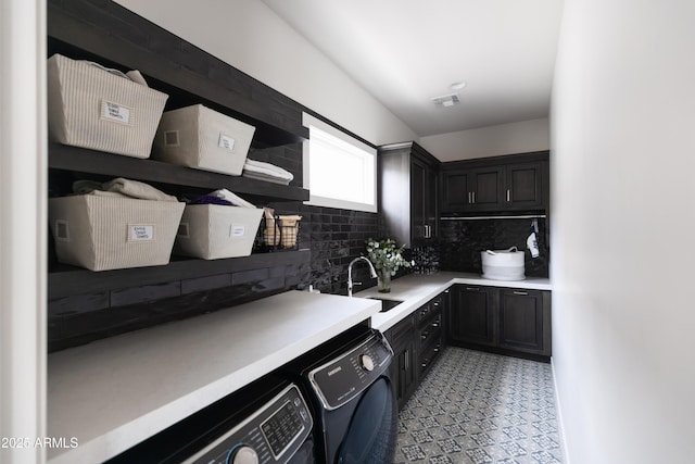 laundry room with washing machine and clothes dryer and cabinet space