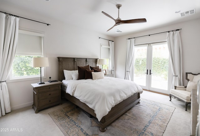 bedroom featuring access to exterior, multiple windows, light carpet, and a ceiling fan
