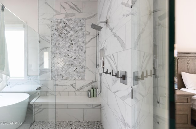 full bathroom with a marble finish shower, a freestanding tub, and tile walls