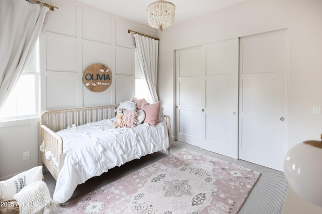 bedroom featuring a chandelier, a closet, and light carpet