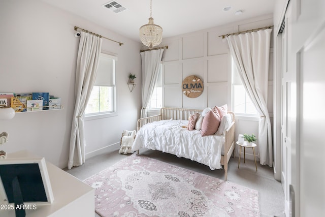 bedroom featuring light carpet, baseboards, and a chandelier