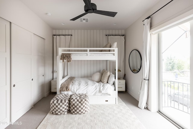 bedroom featuring light carpet, multiple windows, access to exterior, and a closet