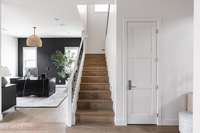stairway with wood finished floors and baseboards