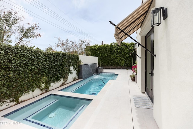 view of swimming pool with an in-ground hot tub and a fenced backyard