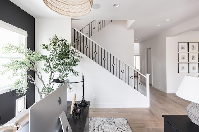stairs with wood finished floors, baseboards, and recessed lighting