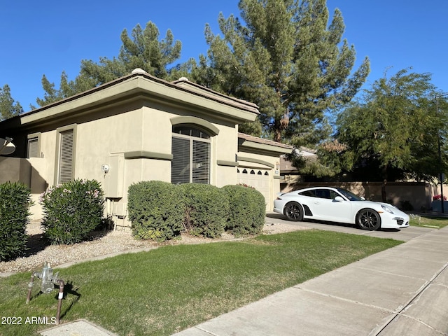 2042 W Periwinkle Way, Chandler, AZ 85248 - view of side of property featuring a garage, stucco siding, a lawn, and concrete driveway