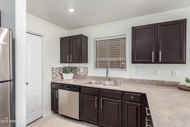 kitchen with appliances with stainless steel finishes, sink, dark brown cabinets, and crown molding