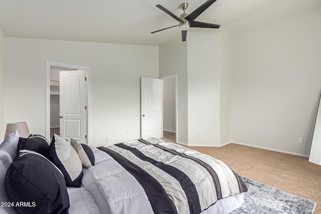 bedroom featuring carpet, lofted ceiling, ceiling fan, and a walk in closet