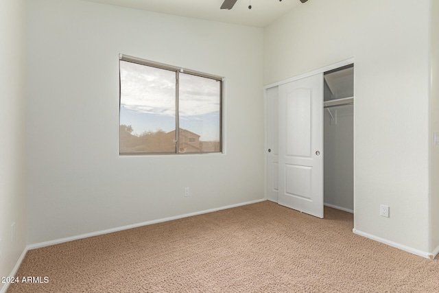 unfurnished bedroom featuring carpet flooring, ceiling fan, and a closet