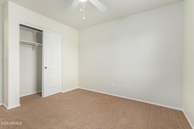 unfurnished bedroom with ceiling fan, a closet, and carpet