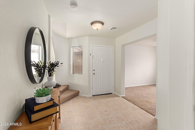 view of carpeted foyer entrance