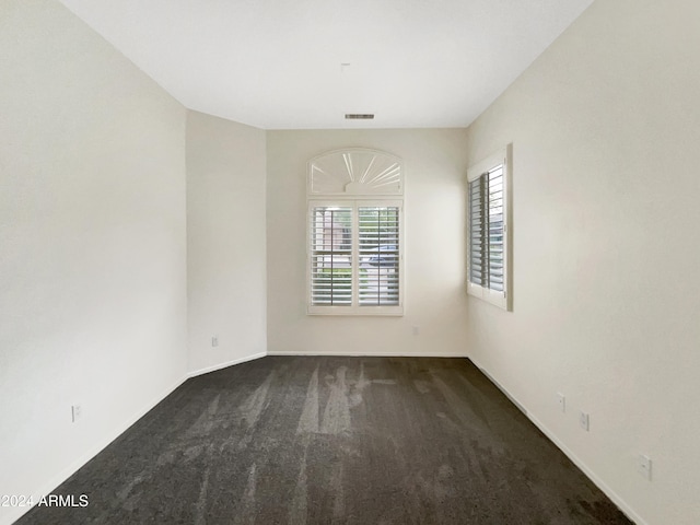 empty room featuring dark colored carpet