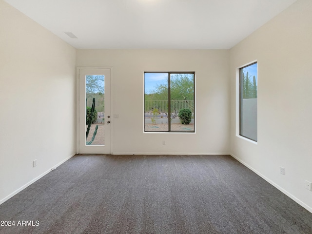 unfurnished room with dark carpet