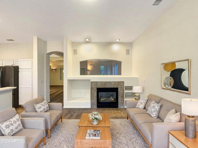 living room with light wood-type flooring and a tile fireplace