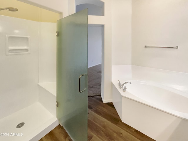 bathroom with plus walk in shower and hardwood / wood-style flooring